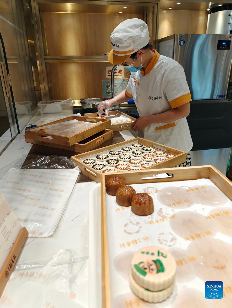 A staff member of Daoxiangcun arranges Chinese pastries in Beijing, capital of China, Aug. 25, 2021.Photo: Xinhua