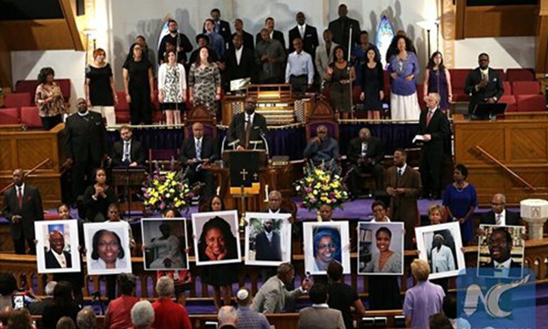 Photographs of the nine victims killed at the Emanuel African Methodist Episcopal Church in Charleston, South Carolina are held up by congregants during a prayer vigil at the Metropolitan AME Church June 19, 2015 in Washington, DC. Photo: Xinhua/AFP PHOTO