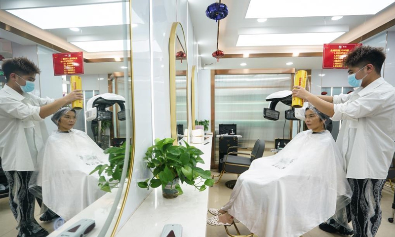 A resident does haircare at a barbershop in Lukou Subdistrict, Jiangning District of Nanjing, east China's Jiangsu Province, Aug. 26, 2021.Photo:Xinhua