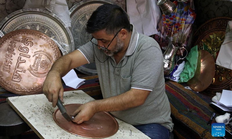 A coppersmith prepares products for customers at the Coppersmith Bazaar in Gaziantep, Turkey, Aug. 26, 2021.Photo:Xinhua