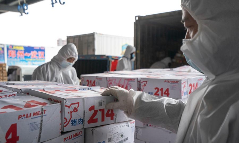 Staff members paste QR codes on imported cold chain food for traceable management at a regional cold chain center in Wuhan, capital of central China's Hubei Province, Jan. 7, 2021. Photo: Xinhua