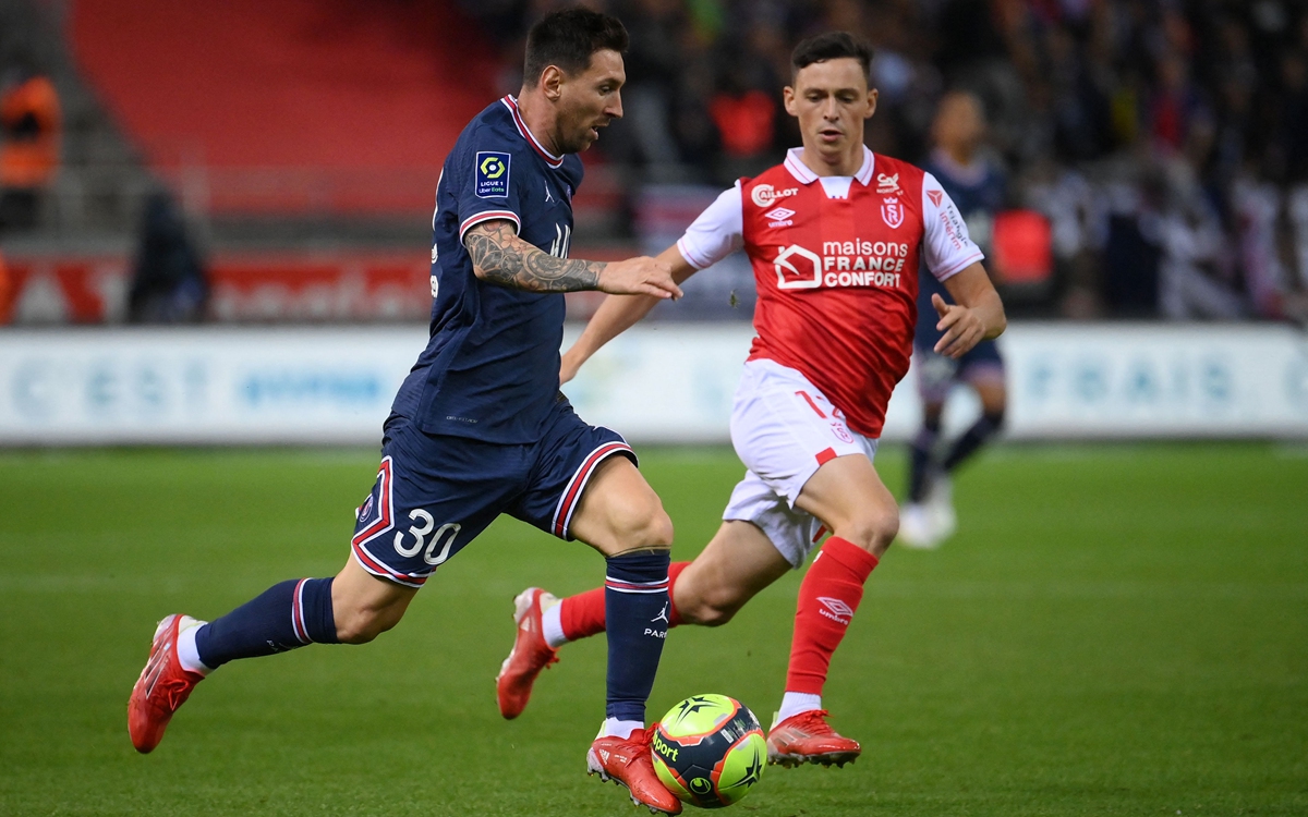 PSG forward Lionel Messi (left) runs with the ball against Reims midfielder Alexis Flips in Reims, France on Sunday. Photo: VCG