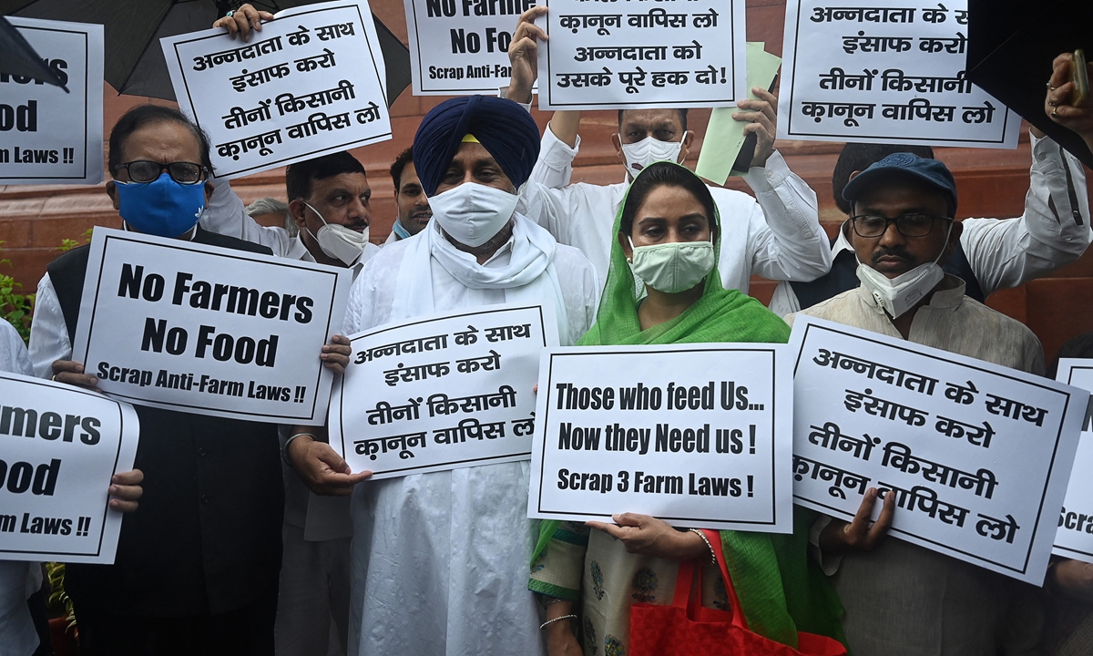 Shiromani Akali Dal (SAD) party president Sukhbir Singh Badal (2L), Harsimrat Kaur Badal (2R) with other leaders hold placards as they protest against the central government?s recent agricultural reforms after arriving for the monsoon session of the Parliament in New Delhi on July 19, 2021. Photo: AFP