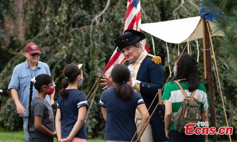 An actor from Washington explains history to children at Green-Wood Cemetery, New York, the United States, Aug. 29, 2021.Photo: CNSphoto 
