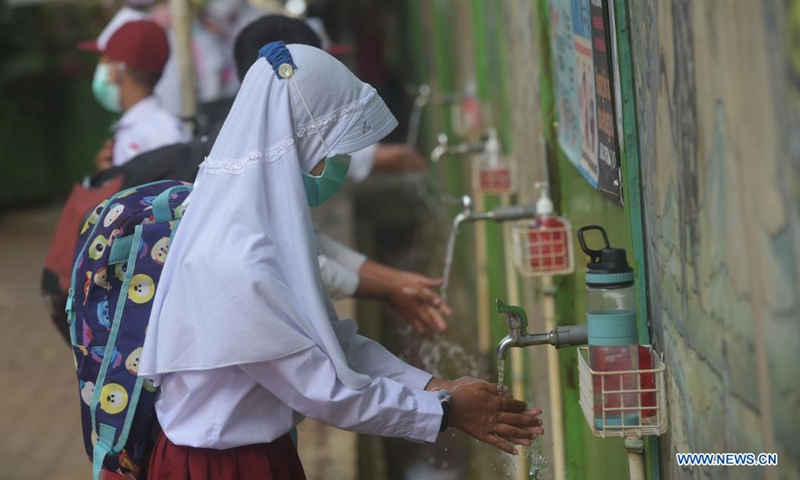 Students wash their hands at the entrance of a school reopened after several months due to COVID-19 pandemic in Jakarta, Indonesia, Aug. 30, 2021. Photo:Xinhua