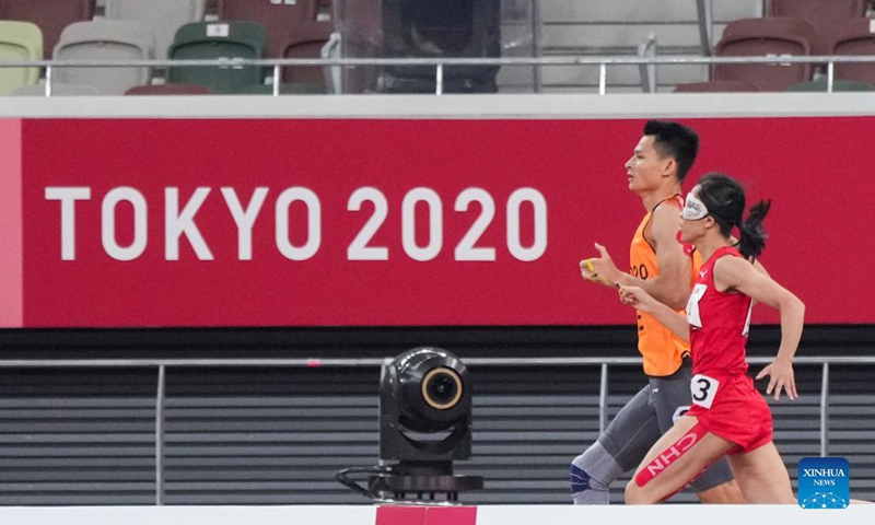 Liu Cuiqing (R) of China running with her guide Xu Donglin competes during the women's T11 class 400m final at the Tokyo 2020 Paralympic Games in Tokyo, Japan, Aug. 27, 2021. Photo: Xinhua