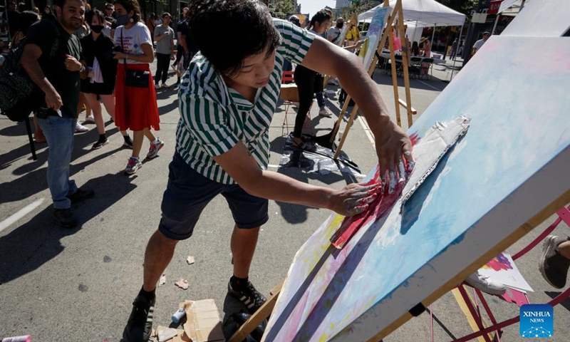 An artist works on his painting during the Art Masters painting competition in Vancouver, British Columbia, Canada, Aug. 29, 2021. The Art Masters is a painting competition with professional artists completing their works within one hour by using various supplies other than brushes. (Photo by Liang Sen/Xinhua) 