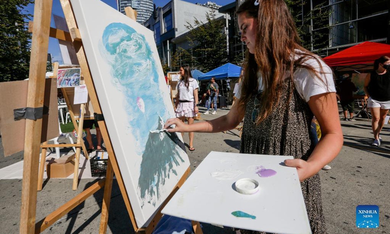 An artist works on her painting during the Art Masters painting competition in Vancouver, British Columbia, Canada, Aug. 29, 2021. The Art Masters is a painting competition with professional artists completing their works within one hour by using various supplies other than brushes. (Photo by Liang Sen/Xinhua) 