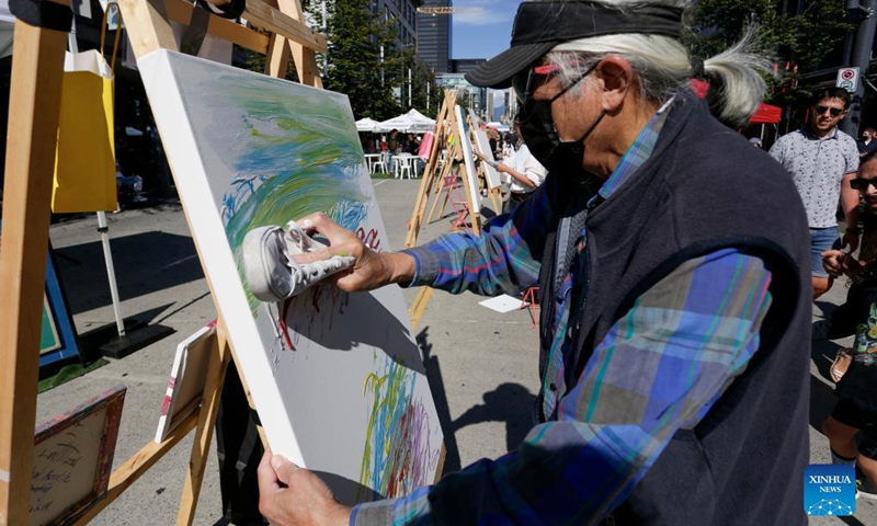 An artist works on his painting during the Art Masters painting competition in Vancouver, British Columbia, Canada, Aug. 29, 2021. The Art Masters is a painting competition with professional artists completing their works within one hour by using various supplies other than brushes. (Photo by Liang Sen/Xinhua) 