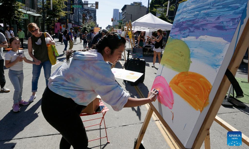 An artist works on her painting during the Art Masters painting competition in Vancouver, British Columbia, Canada, Aug. 29, 2021. The Art Masters is a painting competition with professional artists completing their works within one hour by using various supplies other than brushes. (Photo by Liang Sen/Xinhua) 
