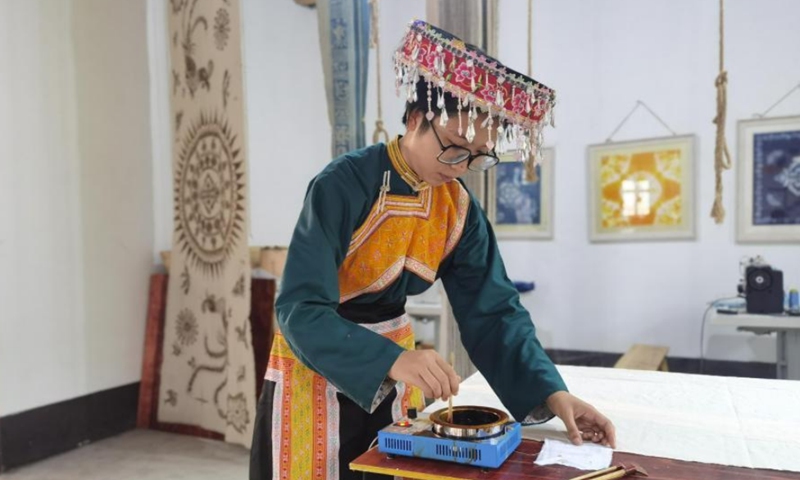 A Miao painting woman draws with an iron wax knife in Jianzhu Intangible Cultural Heritage Experience Base, Gulin County, Luzhou City, Sichuan Province, Aug. 30, 2021. Photo: CNSPhoto