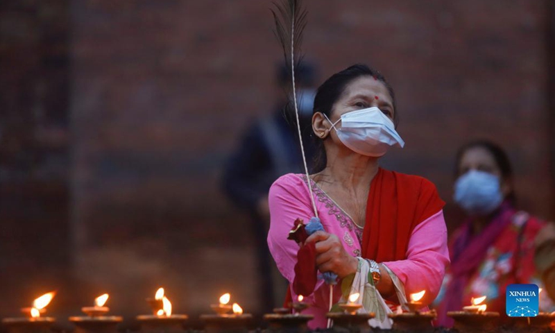 A woman wearing a mask offers a prayer during Krishna Janmashtami at Lord Krishna Temple in Lalitpur, Nepal on Aug. 30, 2021. Krishna Janmashtami festival is celebrated annually to mark the birth anniversary of Hindu God Krishna.(Photo: Xinhua)