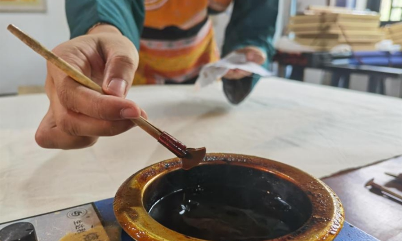 A Miao painting woman draws with an iron wax knife in Jianzhu Intangible Cultural Heritage Experience Base, Gulin County, Luzhou City, Sichuan Province, Aug. 30, 2021. Photo: CNSPhoto