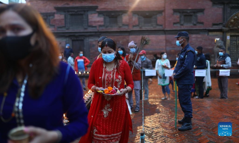 A security personnel ensures that the devotees maintain social distance while waiting to offer a prayer during Krishna Janmashtami at Lord Krishna Temple in Lalitpur, Nepal on Aug. 30, 2021. Krishna Janmashtami festival is celebrated annually to mark the birth anniversary of Hindu God Krishna.(Photo: Xinhua)