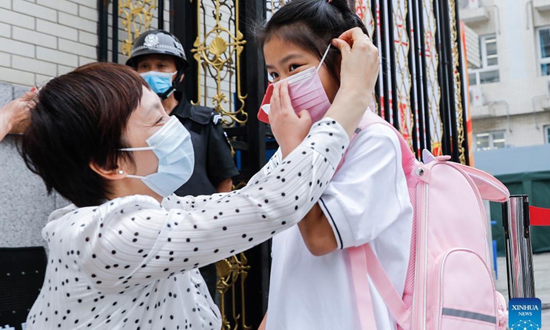 A teacher helps a student wear face mask at the entrance of Beijing Primary School Guangwai branch in Beijing, capital of China, Aug. 31, 2021.Photo:Xinhua