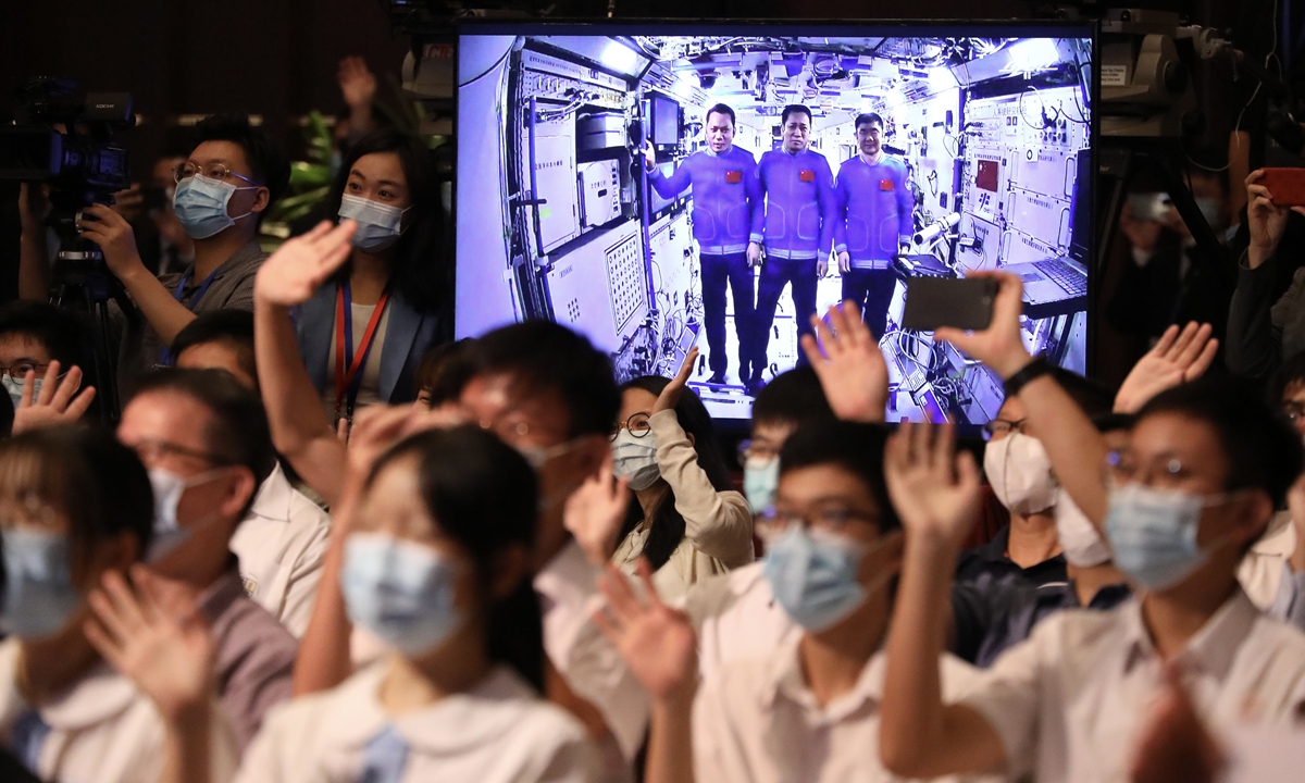 Hong Kong youth wave to three taikonauts on board the Tianhe space station core cabin during an Earth-space talk on Friday.Photo: cnsphoto 