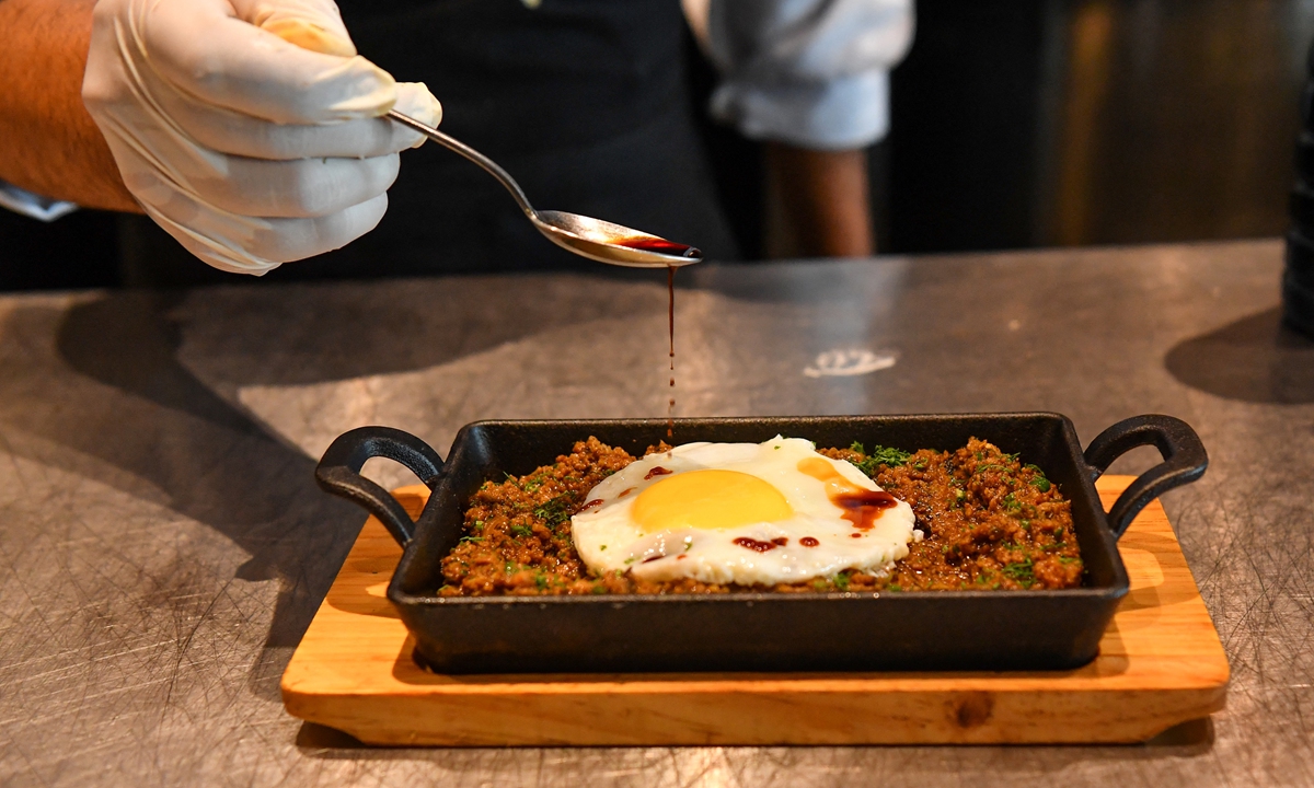 A chef garnishes an egg over Keema, mince lamb meat with Kikkoman Soy Sauce at the Ishaara restaurant in Mumbai on July 16, 2021. Photo: AFP
