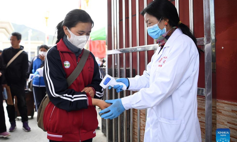 A student has her body temperature checked while entering Luqu Tibetan Middle School in Luqu County, Gannan Tibetan Autonomous Prefecture, northwest China's Gansu Province, Aug. 30, 2021.Photo:Xinhua
