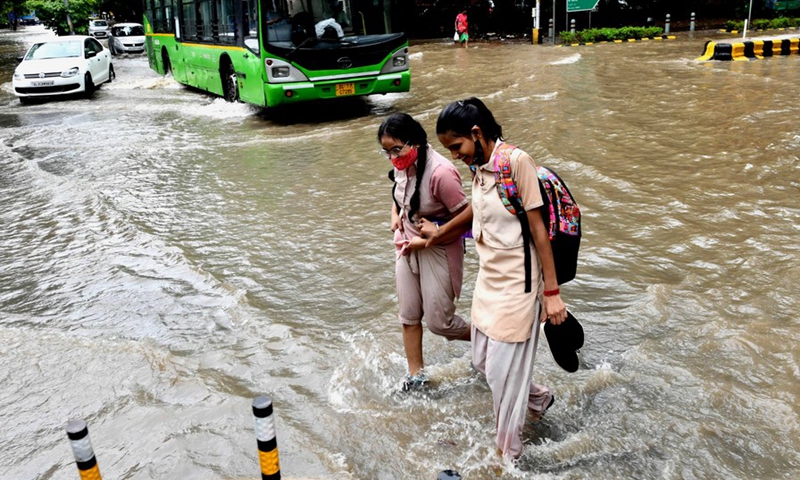 School children moving in a water-logged road after heavy rainfall in New Delhi on Sept. 1, 2021.(Photo: Xinhua)