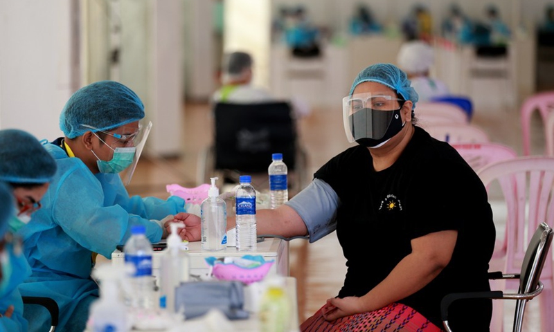 A medical worker checks the physical condition of a woman before she receives the shot of China's Sinopharm COVID-19 vaccine in Yangon, Myanmar, Aug. 29, 2021.(Photo: Xinhua)