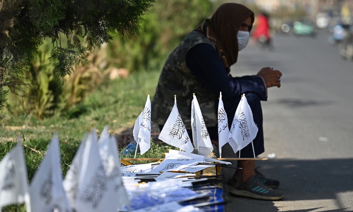 A vendor selling Taliban flags waits by the roadside in Kabul on Thursday. Sources told AFP that the new Afghan cabinet could be presented after morning prayers on Friday. Photo: AFP