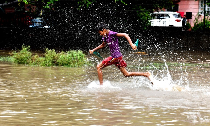 A young boy enjoying in a water-logged road after heavy rainfall in New Delhi on Sept. 1, 2021.(Photo: Xinhua)