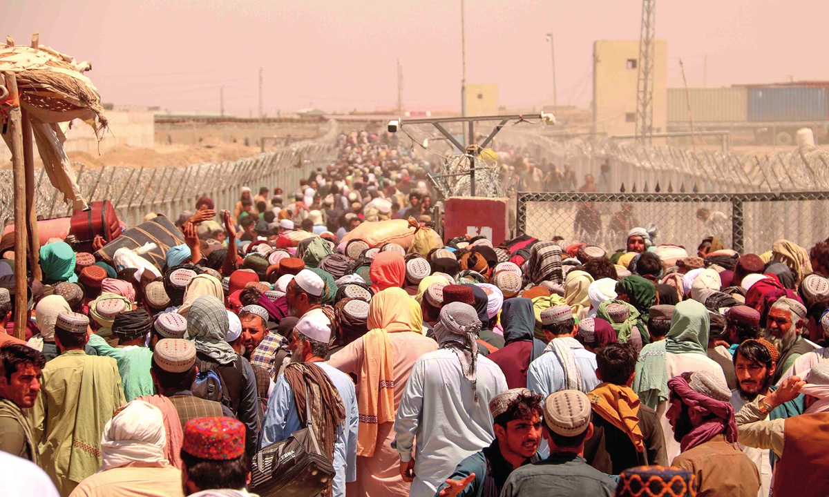 Afghan refugees stranded at the Pakistani-Afghan border wait to cross the border after it was reopened at Chaman, Pakistan on August 13.  Photo: IC