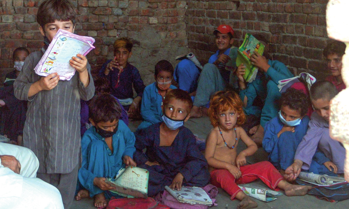 Afghan students receive free education by a volunteer teacher at a refugee camp in Lahore, Pakistan on August 27. Photo: IC