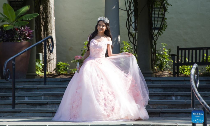 A girl poses for photos during the Quinceanera Fashion Show in Dallas, Texas, the United States, on Sept. 4, 2021. The show was held here Saturday as part of the 4th annual Dallas Arboretum Hispanic Heritage Celebration. (Photo by Dan Tian/Xinhua)
