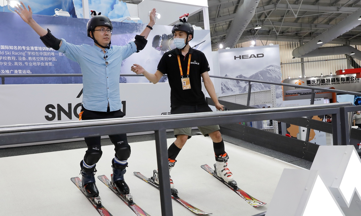 People try a skiing simulator at the CIFTIS on Saturday. Photo: Xinhua

