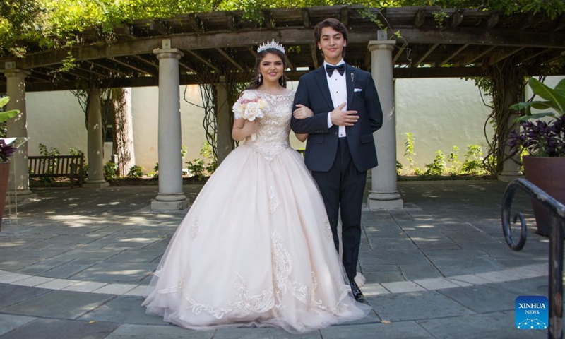 A girl with Quinceanera dress poses for photos during the Quinceanera Fashion Show in Dallas, Texas, the United States, on Sept. 4, 2021. The show was held here Saturday as part of the 4th annual Dallas Arboretum Hispanic Heritage Celebration. (Photo by Dan Tian/Xinhua)