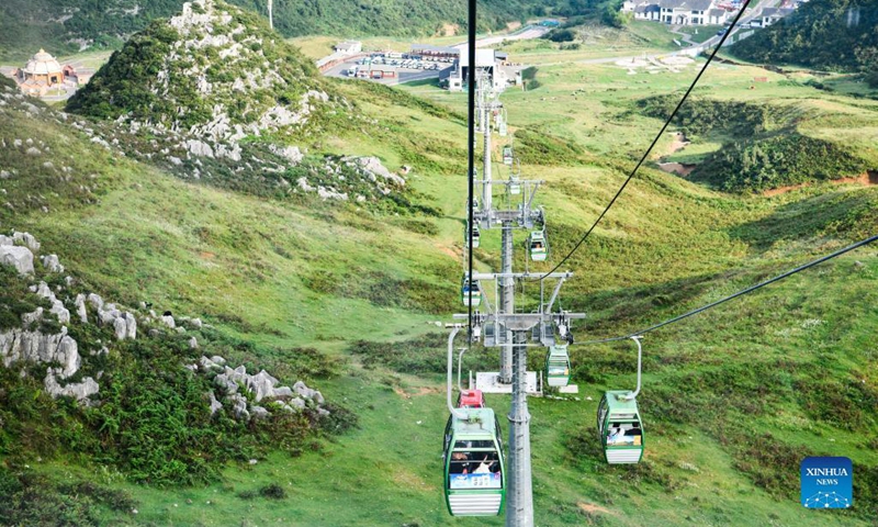 Tourists view the scenery by cable car at a scenic spot in Hezhang County, southwest China's Guizhou Province, Sept. 3, 2021. Hezhang County, featuring beautiful natural scenery and distinctive culture, has ramped up efforts in improving tourism facilities and boosting tourism industry in recent years. Tourism development of the county has given impetus to its rural revitalization. Statistics show that the county has received 4.34 million visitor trips from January to August this year. (Xinhua/Yang Wenbin) 