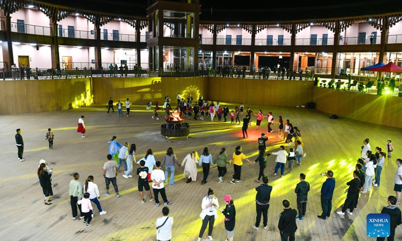 Tourists dance with folk artists at a scenic spot in Hezhang County, southwest China's Guizhou Province, Sept. 3, 2021. Hezhang County, featuring beautiful natural scenery and distinctive culture, has ramped up efforts in improving tourism facilities and boosting tourism industry in recent years. Tourism development of the county has given impetus to its rural revitalization. Statistics show that the county has received 4.34 million visitor trips from January to August this year. (Xinhua/Yang Wenbin) 