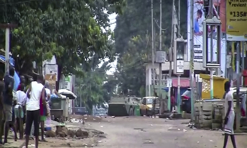 In this image made from video, residents watch as an armored personnel carrier is seen on the streets near the presidential palace in the capital Conakry, Guinea Sunday, Sept. 5, 2021. Photo: CFP