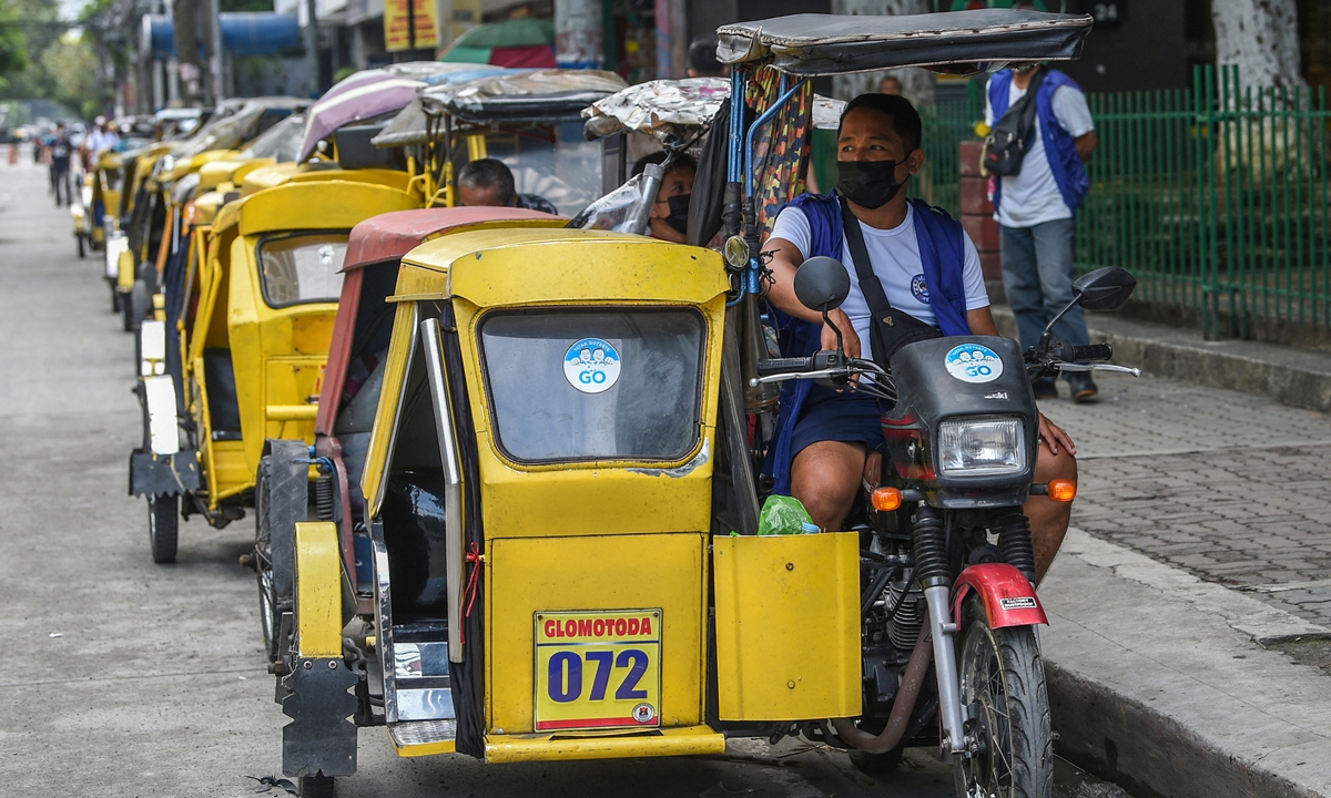 A tricycle taxi driver wearing a face mask waits for customers on a street in Manila, Philippines on Tuesday, a day before the authorities lift a stay-at-home order amid record infections fueled by the contagious Delta variant. Photo: AFP