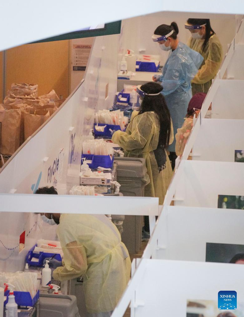 Healthcare staff work inside a COVID-19 rapid test center at the arrivals hall of Vancouver International Airport in Richmond, British Columbia, Canada, on Sept. 7, 2021. Canada began Tuesday to allow entry for fully vaccinated foreigners who have had a full course of a Health Canada-approved COVID-19 vaccine. (Photo by Liang Sen/Xinhua)