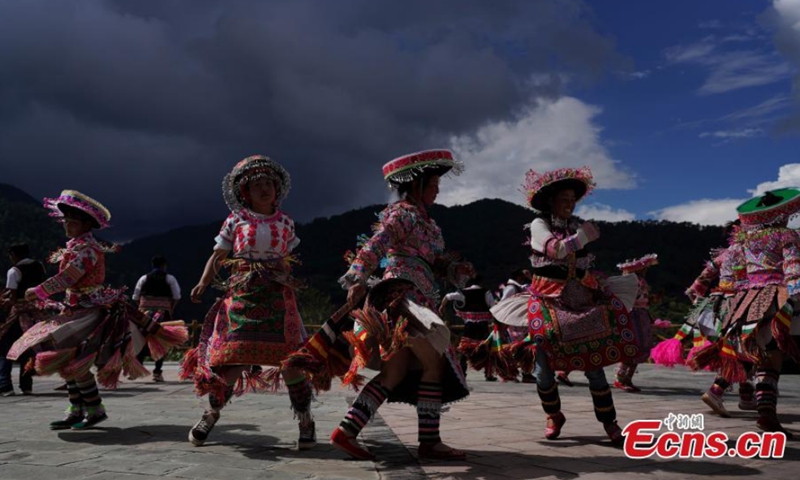 Miao women dance Gameng Kadou at a square in Yongping, Southwest China's Yunnan Province, Sept. 7, 2021. Gameng Kadou, the dance with a history of more than 1,800 years, is a transliteration of the Miao language. The music accompanied by Lusheng, a reed-pipe wind instrument, comes from the original music elements of the Miao people. Photo: CNSphoto