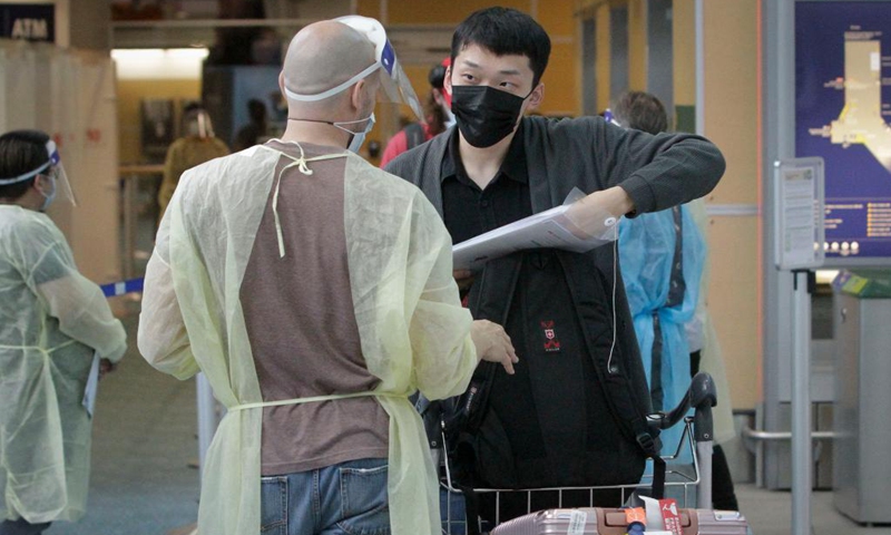 An international traveler presents documents to a healthcare worker at the arrivals hall of Vancouver International Airport in Richmond, British Columbia, Canada, on Sept. 7, 2021. Canada began Tuesday to allow entry for fully vaccinated foreigners who have had a full course of a Health Canada-approved COVID-19 vaccine. (Photo by Liang Sen/Xinhua)