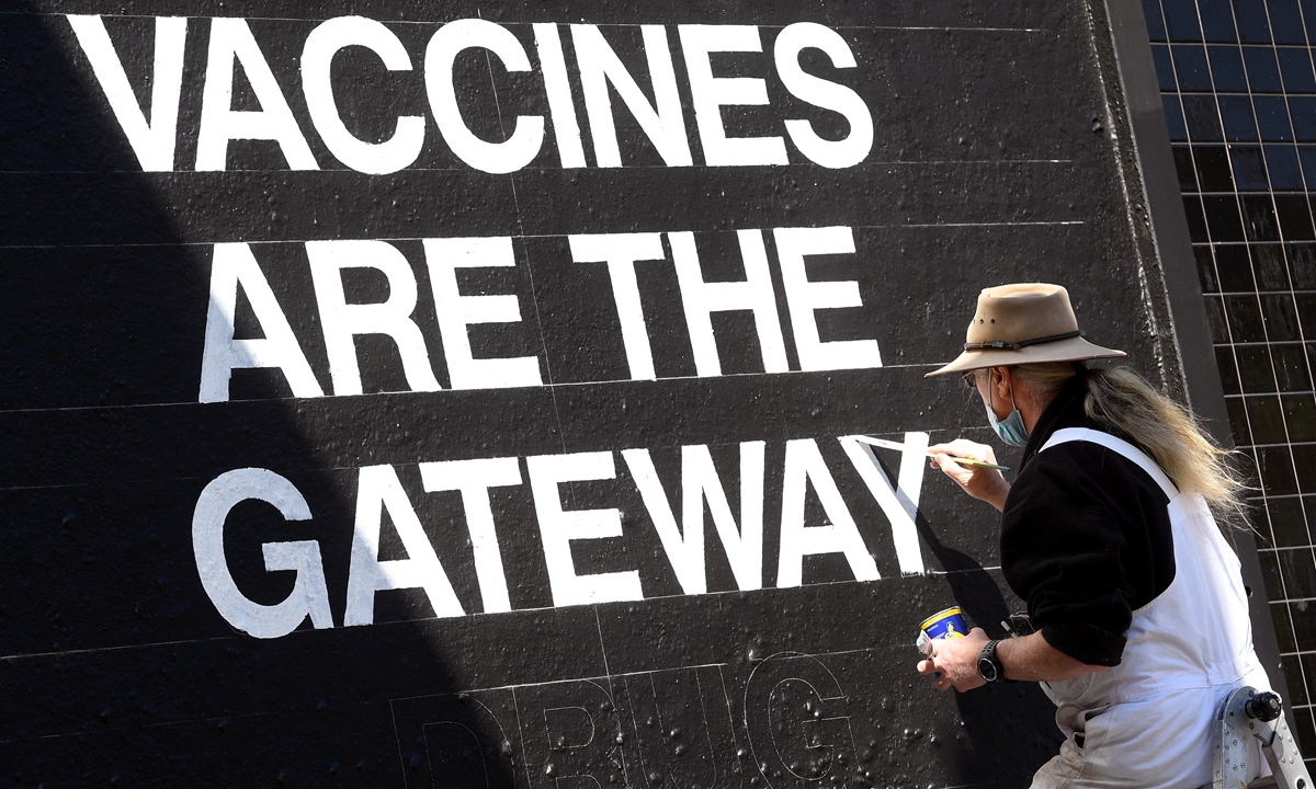 A signwriter paints a message on the side of a building in Melbourne on Wednesday, as the city endures its sixth lockdown while battling an outbreak of the Delta variant of coronavirus. Photo: AFP