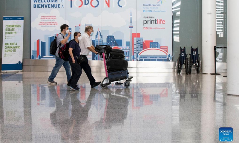 Travelers wearing face masks walk through the arrivals hall at Toronto Pearson International Airport in Mississauga, Ontario, Canada, on Sept. 7, 2021. Canada began Tuesday to allow entry for fully vaccinated foreigners who have had a full course of a Health Canada-approved COVID-19 vaccine. (Photo by Zou Zheng/Xinhua)