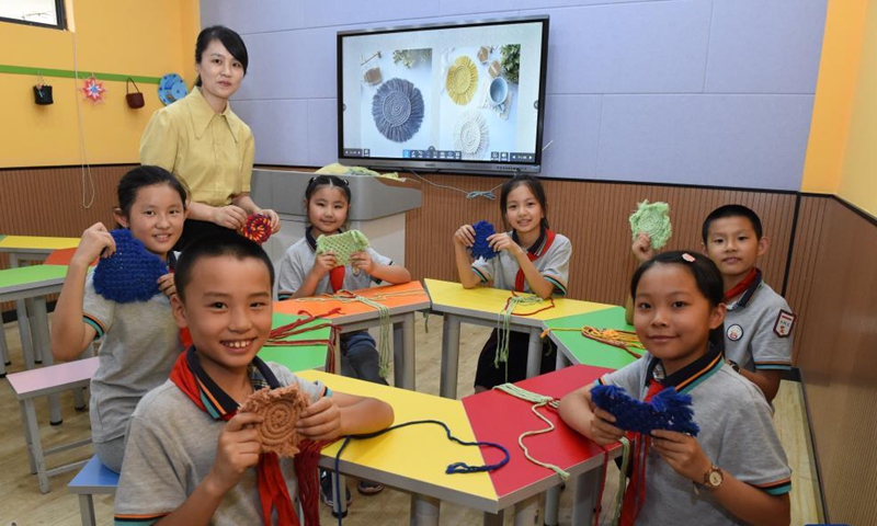 Zhao Xun and her students from a knitting club show their knitting works at Luogang Primary School, Hefei City, east China's Anhui Province, Sept. 8, 2021.Photo:Xinhua