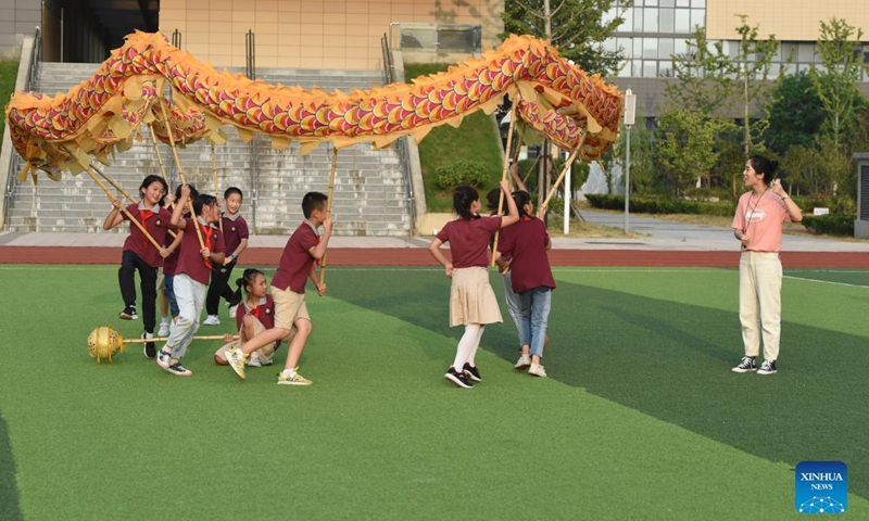 Wang Ling (1st, R) instructs her students at the dragon and lion dance club at Heping Primary School in Hefei City, east China's Anhui Province, Sept. 8, 2021.Photo:Xinhua