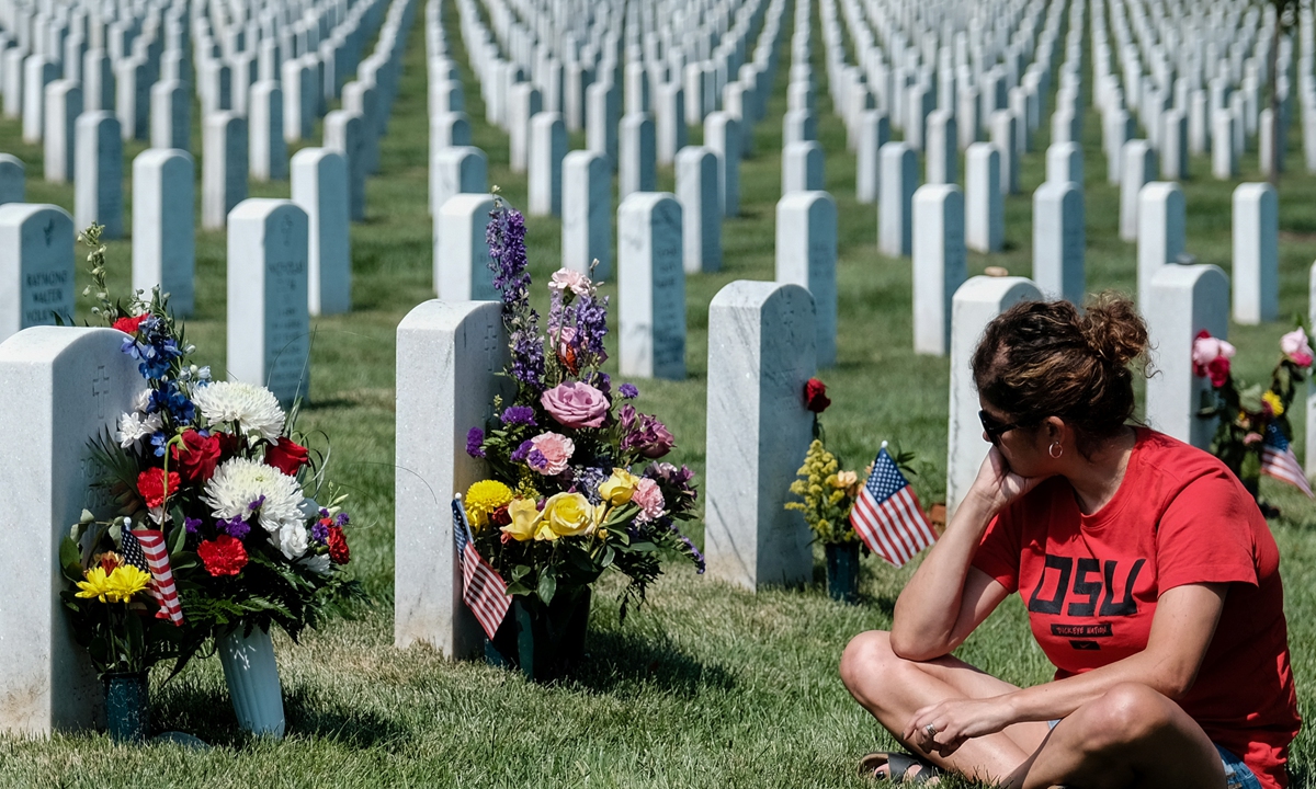 A woman sits at the grave of a fallen service member in Section 64 reserved for service members who lost their lives at the Pentagon.Photo: IC