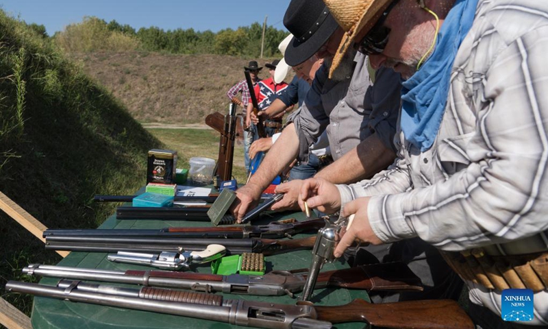 Participants load their guns at the Cowboy Action Shooting Hungarian Championship in Jaszfelsoszentgyorgy, Hungary on Sept. 11, 2021.(Photo: Xinhua)