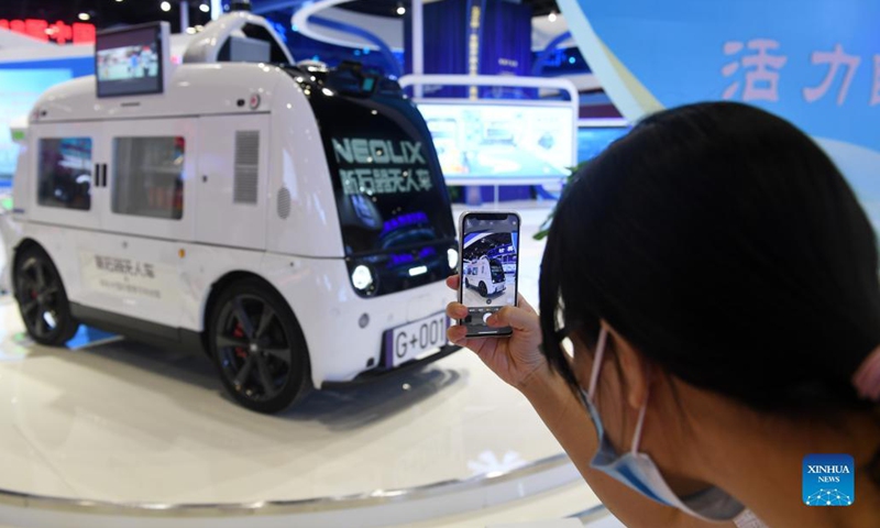 A visitor takes photos of an unmanned car at the 18th China-ASEAN Expo in Nanning, capital of south China's Guangxi Zhuang Autonomous Region, Sept. 11, 2021. The 18th China-ASEAN Expo and China-ASEAN Business and Investment Summit kicked off Friday in Nanning, highlighting the building of a closer China-ASEAN community with a shared future. (Photo: Xinhua)