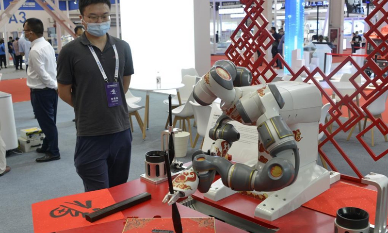 Photo taken on Sept. 10, 2021 shows a robot writing calligraphy at the World Robot Conference held in Beijing, capital of China. The 2021 World Robot Conference is held in Beijing from Sept. 10 to 13. More than 110 enterprises and scientific research institutions brought over 500 products to the exhibition.(Photo: Xinhua)