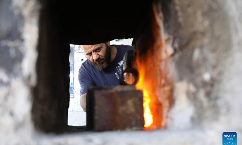 A blacksmith makes agricultural tools at a workshop in Baghdad, Iraq, on Sept. 12, 2021. Iraqi blacksmith Ali al-Khazraji uses his technical expertise to turn scrap iron from old cars into useful agricultural tools such as blades, shovels, axes and sickles.Photo: Xinhua 