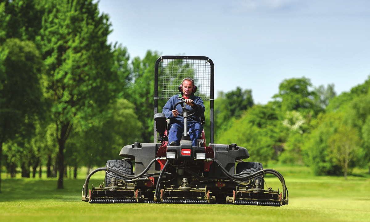 A greenkeeper prepares Cowglen Golf Course in Glasgow, the UK in May 2021. Photo: VCG