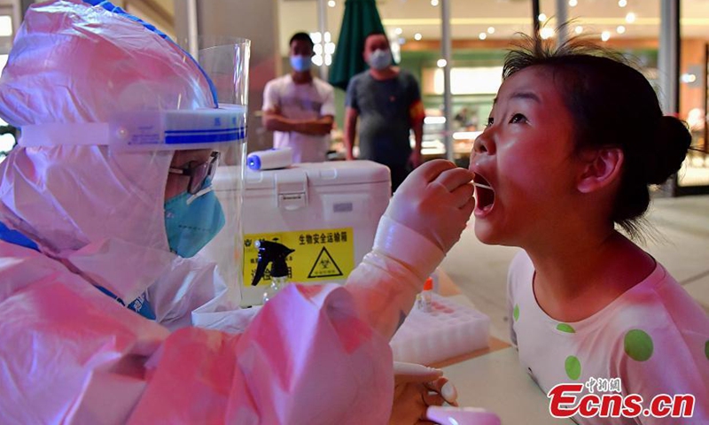 A medical worker takes a throat swab sample from a fourth-grade student for nucleic acid testing in Licheng Street of Xianyou County in Putian City, East China's Fujian Province, September 12, 2021. (Photo: China News Service)
