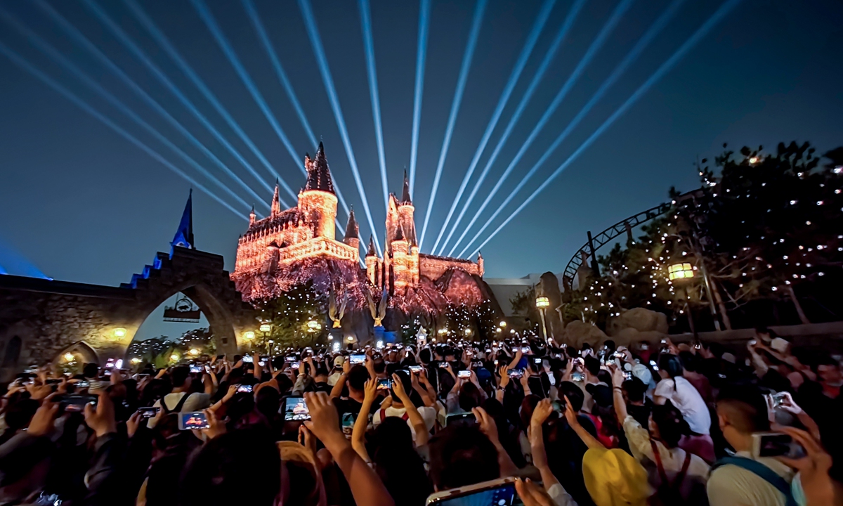 Visitors to the Universal Beijing Resort take photos of a light show at  Hogwarts Castle in the Wizarding World of Harry Potter zone on September 3 during its trial opening. The park started ticket pre-sales on Monday at midnight, with tickets for the official opening day on September 20 snapped up in half an hour. Photo: VCG
